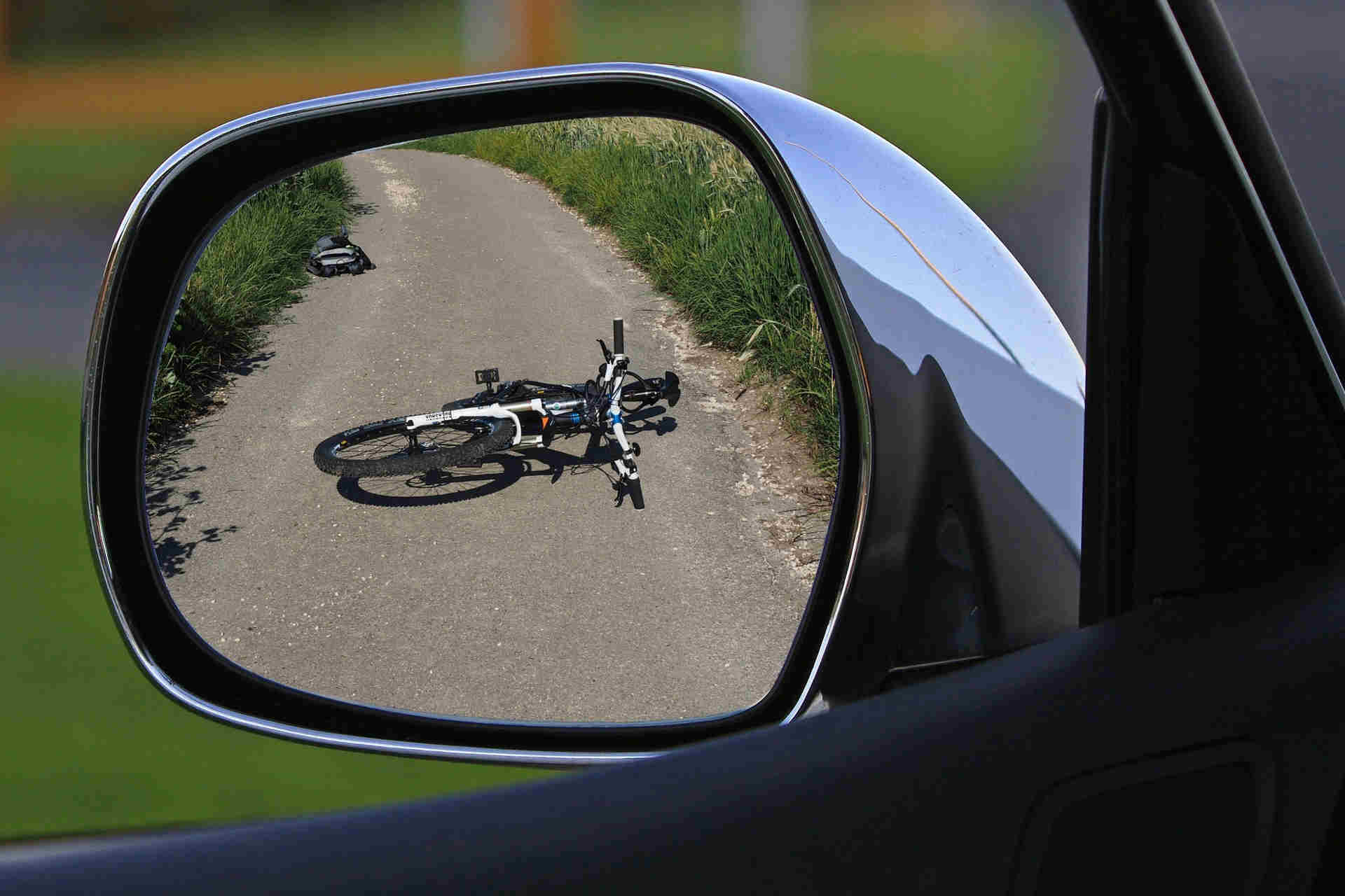 Bicycle on the road seen in a car mirror